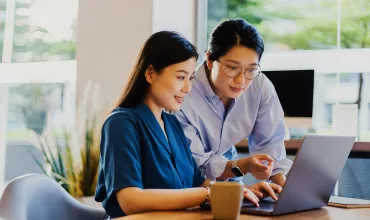 two-colleagues-working-together-on-a-laptop